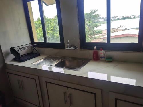 a kitchen counter with a sink and two windows at BRUNCH RESIDENCE BoUAKE in Kodia Kofikro