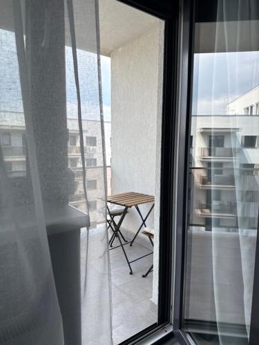a balcony with a table and a glass window at Blue Oasis Apartment - Hils Brauner in Bucharest