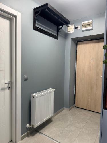 a room with a door and a heater on a wall at Blue Oasis Apartment - Hils Brauner in Bucharest