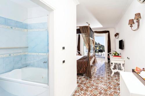 a bathroom with a tub and a bedroom at Regina Cristina in Capri