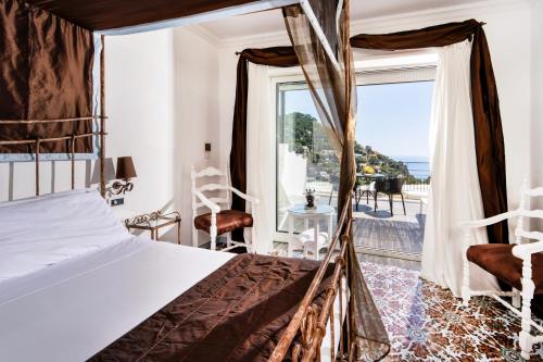 a bedroom with a bed and a large window at Regina Cristina in Capri