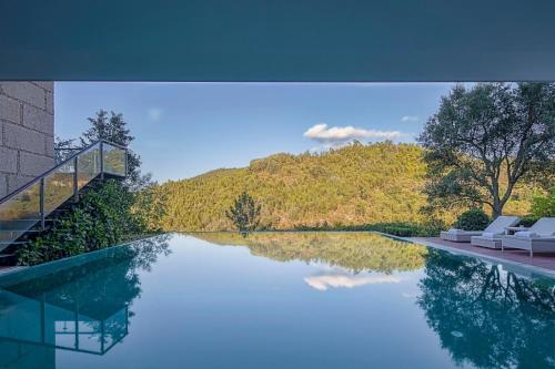 a swimming pool with a view of a mountain at Infinity Villa Cavez - Luxury Retreat in Moimenta