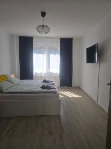 a bedroom with a bed and a window with blue curtains at Simple Modern Apartment in Duisburg