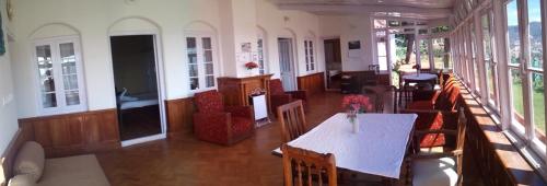 a dining room with a table and chairs in a building at Wyoming Heritage in Ooty