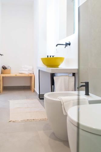 a bathroom with a yellow sink and a tub at Casale Santa Rosalia Charme Villas and Rooms in San Mauro Cilento