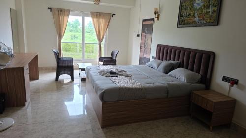 a bedroom with a bed and a table and chairs at Hame Lana Resort in Mawlynnong