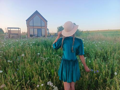 a woman in a blue dress walking in a field at Zielone Wzgórze komfortowy klimatyzowany domek z balią z aeromasażem in Kłodzko