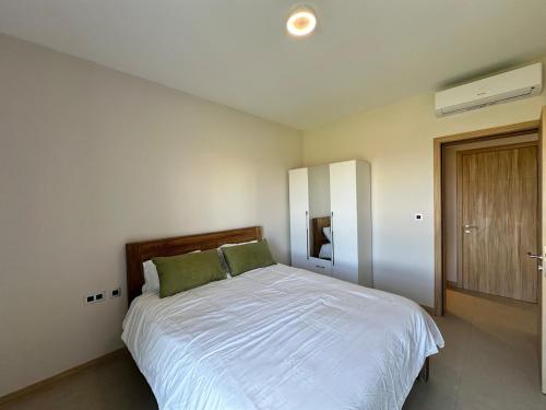 a bedroom with a large white bed with green pillows at Verdant Horizon in Moka
