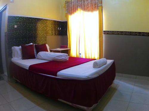 a large bed in a room with a window at Taba Yama Trip & Homestay in Ketapang