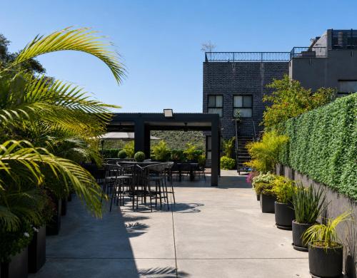a patio with tables and chairs and plants at בוטיק אשתאול - 4 סוויטות מפנקות עם ג'קוזי פרטי ו2 בריכות במתחם in Eshtaol