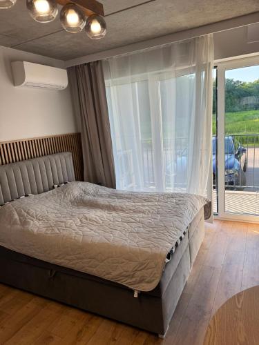 a bedroom with a bed and a large window at Róża- Lotnisko in Wrocław