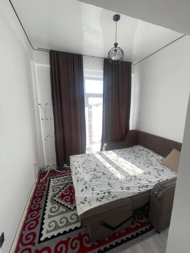 a small bedroom with a bed and a rug at Diamond resort in Bosteri