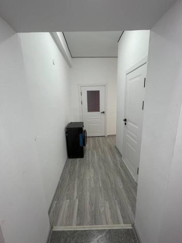a hallway with a room with white walls and a door at Diamond resort in Bosteri