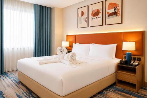 a hotel room with a bed with a towel animal on it at Warwick Hotel Al Safa - Jeddah in Jeddah