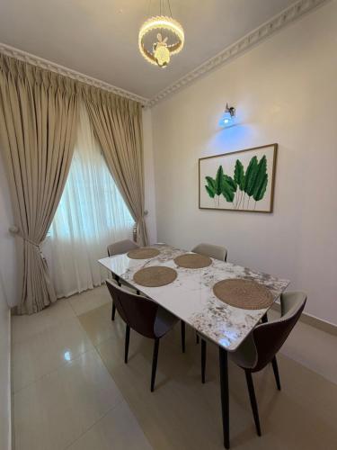 a dining room with a white table and chairs at Was Homes in Abuja