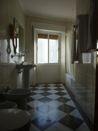 a bathroom with a black and white checkered floor at Hotel San Pedro in Carmona