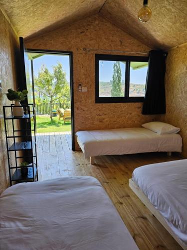 a room with two beds and a window at מאי טאי ויליג' - 8 בקתות מהממות מול הנוף in Mas'ada