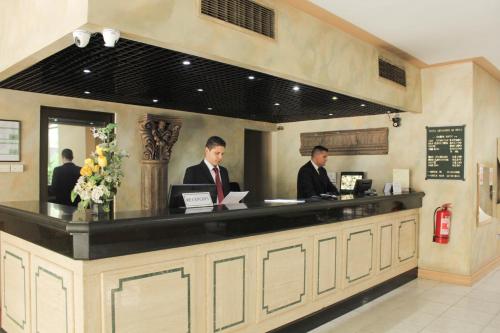 two men sitting at a counter in a restaurant at Hotel Leonardo da Vinci in Santiago