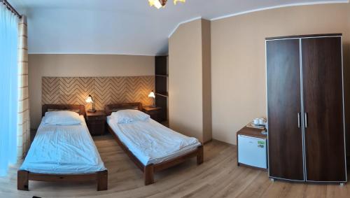 a room with two beds and a cabinet at Willa Arkadia in Władysławowo