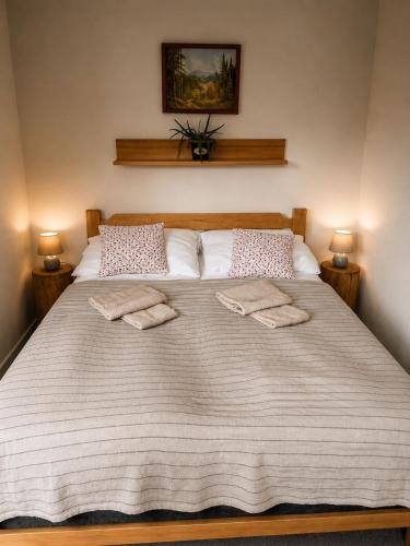 a large white bed with two towels on it at Apartmany Ruby in Rokytnice nad Jizerou