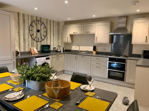 a kitchen with a dining table and a kitchen with white cabinets at The Stokesay Boutique Townhouse Ludlow in Ludlow
