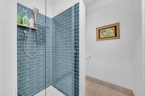 a bathroom with a shower with blue tiles at 11 Guests 6BR, Granny Flat, 3 Kitchens, Hiking in Dernancourt
