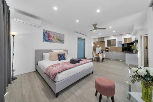 a white bedroom with a bed and a kitchen at 11 Guests 6BR, Granny Flat, 3 Kitchens, Hiking in Dernancourt