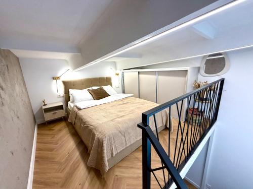 a bedroom with a bed in a room with a staircase at The Emerald Loft I Terrace I Free Parking in Kaunas