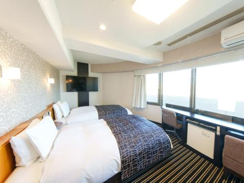 a hotel room with a bed and a large window at APA Hotel Osaka Temma in Osaka