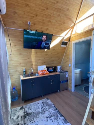 a kitchen with a sink and a tv on the wall at Baet Home in Bayetovka