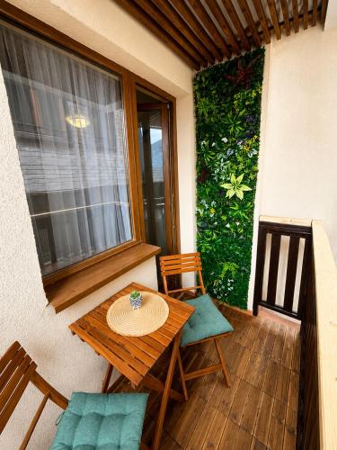 a table and chairs on a balcony with a window at Апартамент почивка в планината in Pamporovo