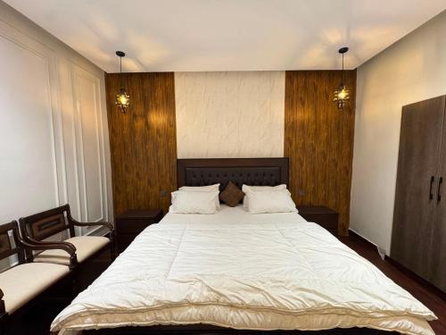 a bedroom with a large white bed with two chairs at Velenburg Retreat in Upper Topa