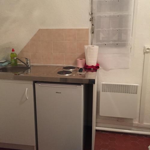 a small kitchen with a sink and a stove at Petit studio haussmannien in Marseille