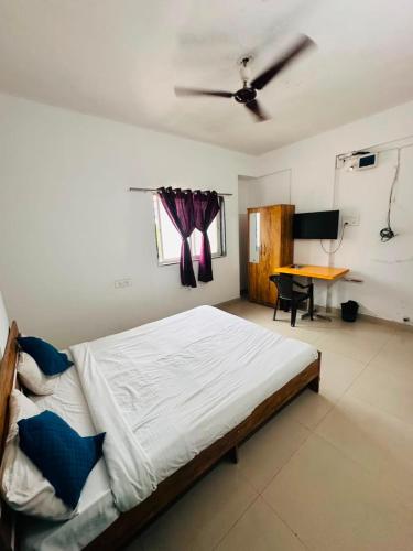 a bedroom with a bed and a desk in it at Hotel Deluxe in Hinjewadi