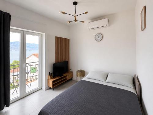 a bedroom with a bed and a large window at Apartman Bugenvila Postira Brač in Postira