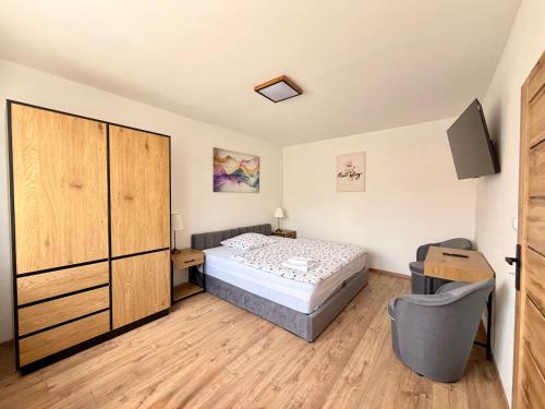 a bedroom with a bed and a cabinet and a tv at Apartmánový byt Kostička 7 in Kadaň