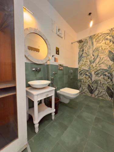 a bathroom with a sink and a toilet and a mirror at THHPSOCIETY - Exstacy stays & cafe - Your Romantic & Cozy Getaway - Mountain view , Hot tub , Parking - MUKTESHWAR in Mukteshwar