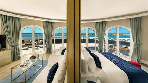 a bedroom with a bed and a view of the ocean at M Hotels at Porto Marina in El Alamein