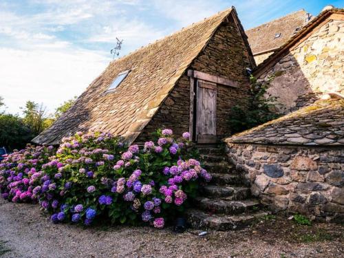 a stone house with flowers in front of it at Château de Taussac in Taussac