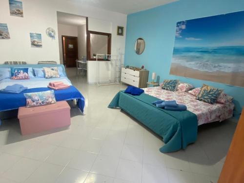 two beds in a room with blue walls at Green House in Briatico