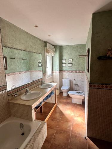 a bathroom with two sinks and a tub and a toilet at Xanela da Ría in Quenje
