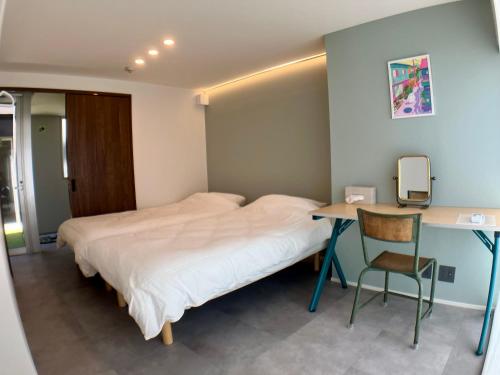 a bedroom with a bed and a desk with a chair at Guesthouse Matsu 別館 in Osaka