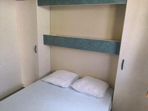 a bed in a small room with two pillows at Camping Pezza Cardo in Porto-Vecchio