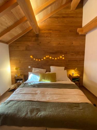 a bedroom with a large bed with wooden walls at Chalet Chante Guisane in Saint-Chaffrey