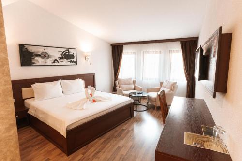 a hotel room with a bed with a dress on it at Hotel Centrum Prizren in Prizren