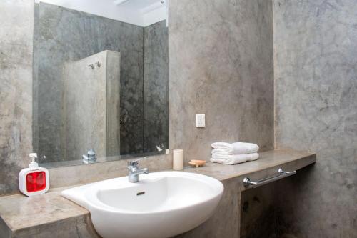 a bathroom with a white sink and a mirror at Charming Penthouse -Holidays Houses in Malindi