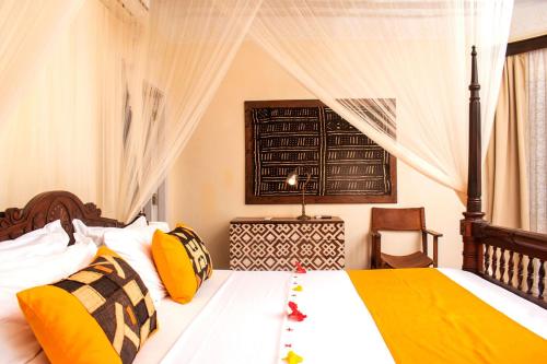 a bedroom with a large bed with yellow and black pillows at Charming Penthouse -Holidays Houses in Malindi