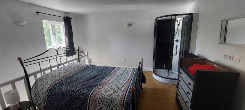 a bedroom with a bed and a dresser and a mirror at Le gîte des Allains in Sainte-Suzanne-en-Bauptois