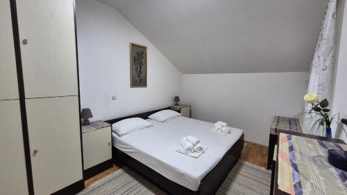 a small room with a bed with white sheets at Sunshine Apartments Podstrana in Podstrana