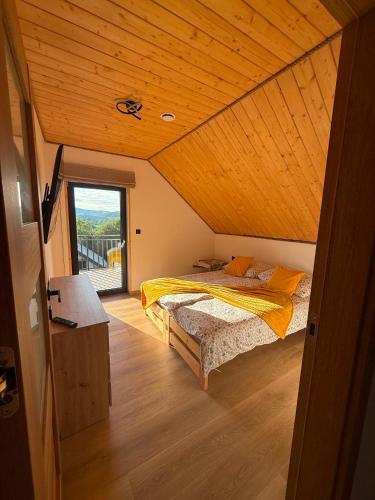 a bedroom with a bed and a wooden ceiling at Widokówka in Baligród